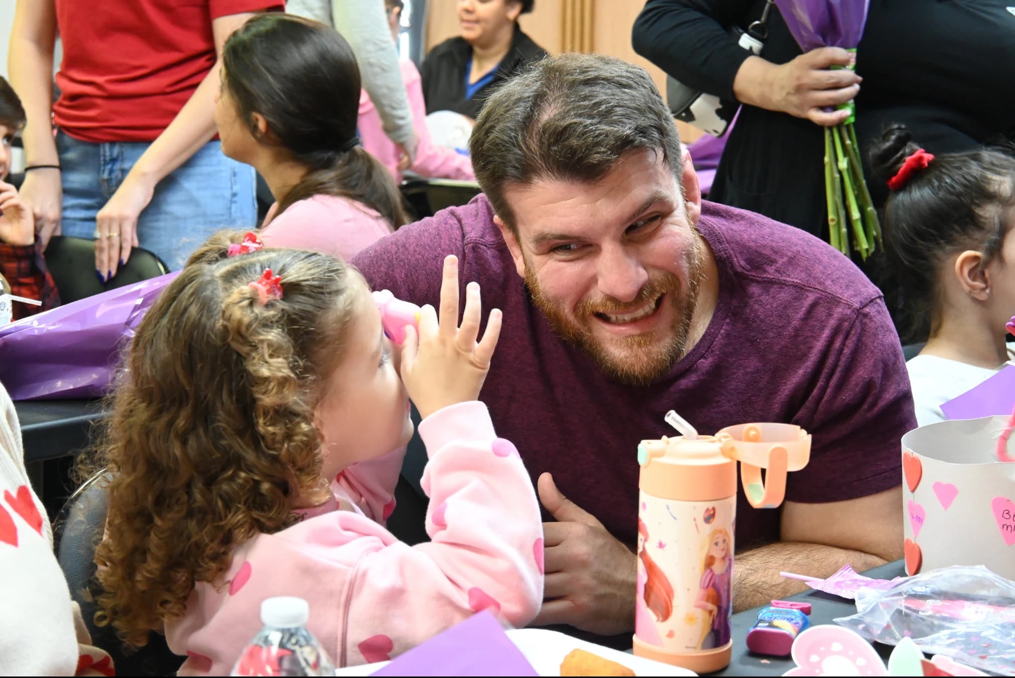 A father and his daughter laughing together at a table